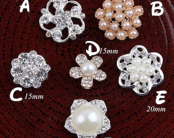 May include: Assortment of six decorative embellishments in silver and gold tones. The embellishments are in the shape of flowers and feature rhinestones and pearls. The embellishments are labeled with letters A through F and measurements in millimeters.