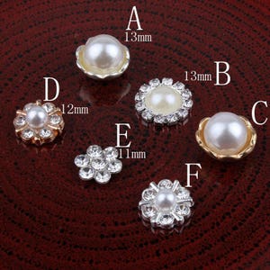 Puede incluir: Surtido de adornos de perlas y diamantes de imitación en varios tamaños y estilos. Los adornos tienen un diámetro de 11 mm, 12 mm y 13 mm.