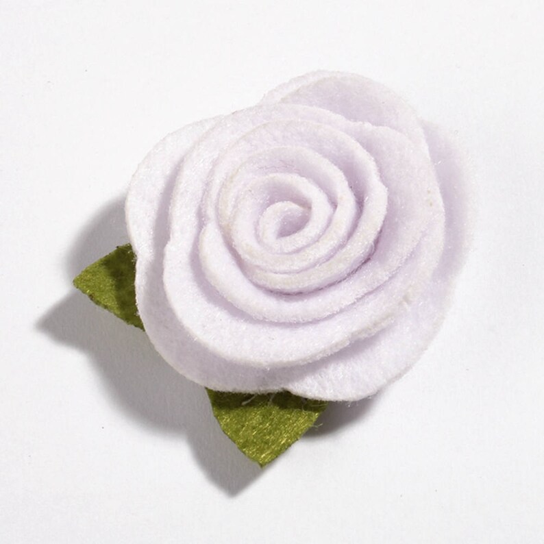 K&ouml;nnte beinhalten: Eine hellviolette Filzrose mit einem gr&uuml;nen Filzblatt. Die Rose hat mehrere Bl&uuml;tenblattschichten und ein eng gewickeltes Zentrum. Das Blatt ist einfach und flach. Die Blume ist wahrscheinlich ein Bastelbedarf oder ein dekoratives Element.