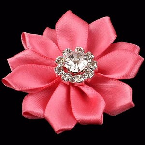 May include: A pink satin flower with a silver rhinestone center.