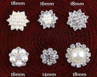 May include: Six silver-toned embellishments with pearl and rhinestone accents. The embellishments are arranged in two rows of three. The top row has two 18 mm embellishments and one 16 mm embellishment. The bottom row has one 16 mm embellishment, one 14 mm embellishment, and one 18 mm embellishment.
