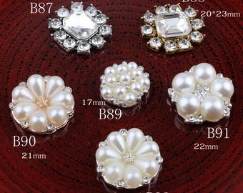 May include: Assortment of pearl and rhinestone embellishments in various sizes and styles. The embellishments are silver and gold toned and feature a variety of pearl and rhinestone designs. The embellishments are labeled with the product codes B87, B88, B89, B90, B91, and B92.
