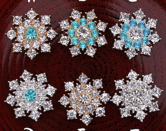 May include: Six snowflake-shaped rhinestone embellishments in various colors, including clear, gold, and turquoise. The embellishments are arranged in two rows of three, labeled A through F.