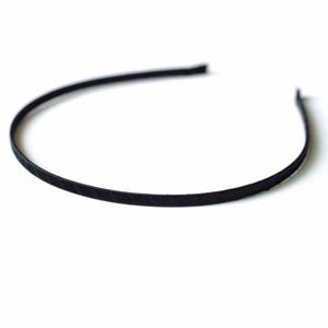 May include: A black headband made of a thin, flexible material. The headband is smooth and has a subtle sheen.