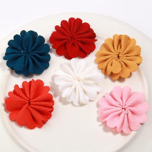 Puede incluir: Seis adornos florales de tela en varios colores: turquesa, rojo, amarillo, blanco, rosa y coral. Cada flor tiene un diseño de pétalos texturizados y en capas, ideal para manualidades o proyectos decorativos.