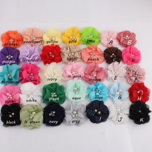 May include: Assortment of 25 fabric flower hair clips in various colors, including orange, peach, yellow, gold, lime, purple, lavender, red, khaki, peach, turquoise, fuchsia, ivory, light pink, mauve, pink, white, green, aqua, blue, black, light green, navy, gray, and brown. Each flower has a pearl center and some have polka dots.