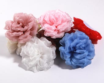 Puede incluir: Un conjunto de flores de tela en varios colores, incluyendo rosa, blanco, azul y rojo. Las flores tienen un diseño de pétalos en capas y están dispuestas sobre una superficie blanca. Ideales para manualidades o decoración.
