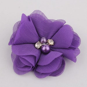 May include: Purple fabric flower with three pearl and rhinestone embellishments.