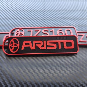 May include: Three black and red keychains with the Toyota logo and the text "1JZ S160" and "ARISTO" and "ZS1"