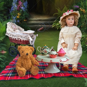 May include: A porcelain doll with a white dress and pink bow sits at a tea party with a teddy bear, cupcakes, and a teapot. The doll is sitting on a red and green plaid blanket.