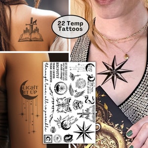 May include: A sheet of 22 temporary tattoos featuring black and white illustrations of stars, wings, swords, a compass, a book, a crescent moon, and other designs. The text "Light it up" and "Through love, all is possible" are included on the sheet.