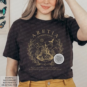 Może przedstawiać: Czarny T-shirt z złotym wzorem graficznym przedstawiającym zamek, drzewa i nietoperza. Na wzorze nadrukowany jest tekst "ARETIA - RIORSON HOUSE". Wz&oacute;r otoczony jest wieńcem z liści. W prawym dolnym rogu wzoru znajduje się mały srebrny okrąg z tekstem "SPARROW & WILDE ORIGINAL ART".