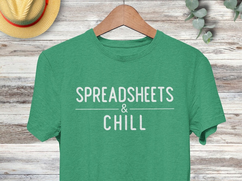 Puede incluir: Una camiseta verde con el texto "SPREADSHEETS & CHILL" en blanco.