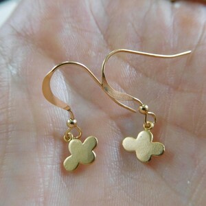 Peut inclure: Une paire de boucles d'oreilles en forme de papillon en or avec un design simple. Les boucles d'oreilles sont en métal lisse et brillant et ont un aspect délicat et féminin.