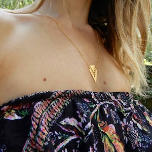 Peut inclure: Un collier en or avec un pendentif en forme de triangle géométrique. Le pendentif est réalisé dans un design délicat et ajouré.