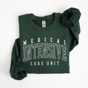 May include: A dark green sweatshirt with white text that reads "MEDICAL INTENSIVE CARE UNIT".