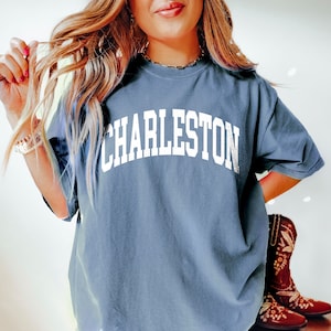 May include: A blue t-shirt with the word "CHARLESTON" printed in white on the front.