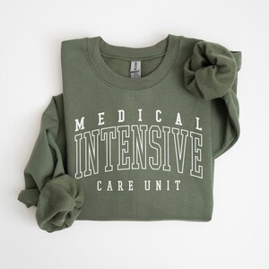 May include: A green sweatshirt with white text that reads "MEDICAL INTENSIVE CARE UNIT".