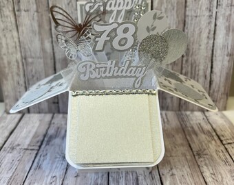 May include: A white and silver pop-up card with the words "Happy 78th Birthday" and a silver butterfly.