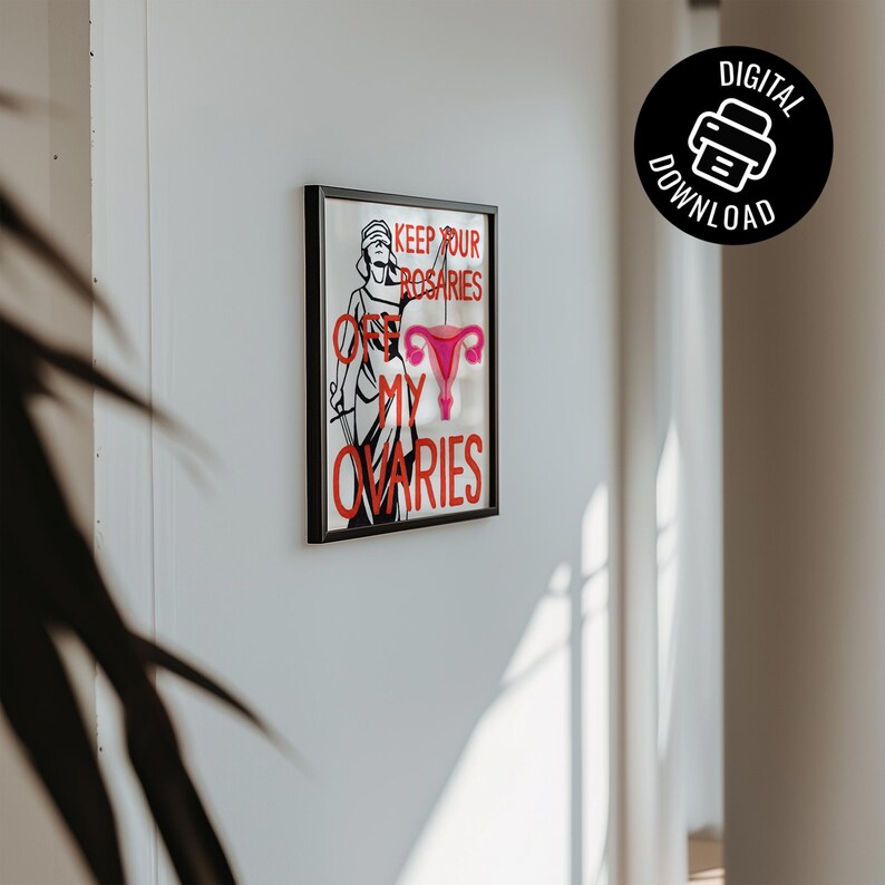 A minimalist mockup of the feminist law and justice art print in a thin black frame, hanging on a clean white gallery wall with soft shadows.
