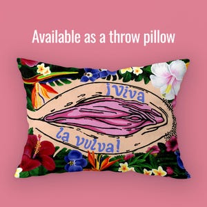 A rectangular throw pillow featuring the "Viva la Vulva" artwork. The design is oriented horizontally to fit the pillow shape, maintaining the vibrant floral border. Above it, text reads "Available as a throw pillow."