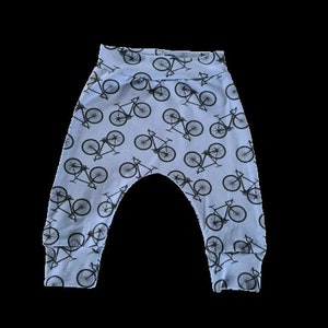 Op de afbeelding: Lichtblauwe babybroek met een zwarte fiets print.