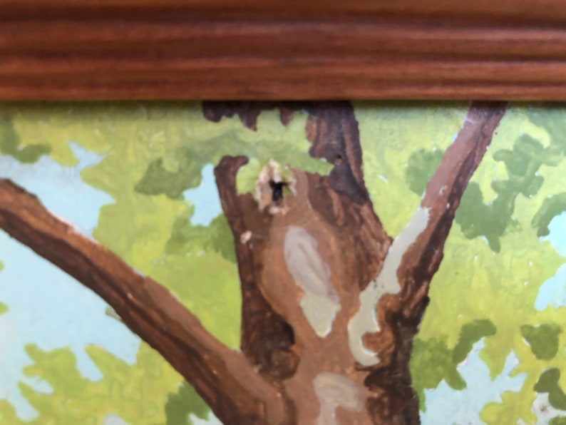 Peut inclure: Un gros plan sur une peinture repr&eacute;sentant un arbre au tronc brun et aux feuilles vertes. L'arbre est peint sur un fond de ciel bleu avec des nuages blancs.