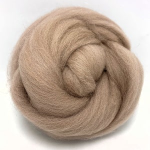 May include: A close-up of a ball of light brown wool roving. The wool is soft and fluffy, and it is perfect for felting or spinning.
