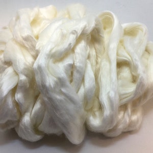 May include: A large pile of white silk fibers. The fibers are soft and fluffy, and they are perfect for spinning or weaving.