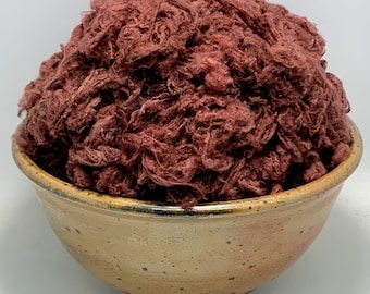 May include: A bowl filled with a large amount of loose, red-brown cotton fibers.