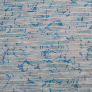 Peut inclure: Un tissu texturé présentant un motif à rayures horizontales bleu clair et blanc. La surface est recouverte de formes bleues abstraites et dispersées qui ressemblent à des marques organiques fluides ou à des coups de pinceau stylisés.