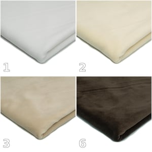 Op de afbeelding: Een set van vier gevouwen stofstalen gelabeld met de nummers 1, 2, 3 en 6. De kleuren van de stof zijn helderwit, crème, lichtbeige en donkerbruin. Elke staal is gevouwen om een glad, zacht getextureerd oppervlak met subtiele plooien te tonen.