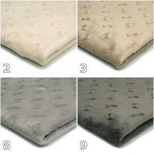 Op de afbeelding: Een set van vier gevouwen pluche dekens met een verhoogde noppenstructuur. De dekens worden getoond in vier verschillende tinten: crème gelabeld 2, beige gelabeld 3, lichtgrijs gelabeld 8 en donkergrijs gelabeld 9, elk met een zacht oppervlak.