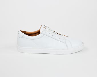 May include: White leather low-top sneakers with a white rubber sole.
