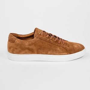May include: A pair of brown suede low-top sneakers with white laces and a white rubber sole.