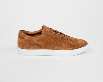 May include: A pair of brown suede low-top sneakers with white laces and a white rubber sole.
