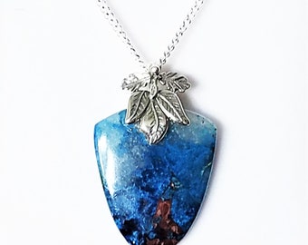 May include: A silver chain necklace with a blue and white gemstone pendant and silver leaf accents.