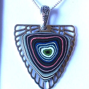 May include: A silver pendant necklace with a triangular frame and a colorful agate stone in the center. The stone has a swirling pattern of blue, green, red, and white.