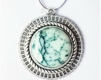 May include: A silver pendant necklace with a round green and white agate stone set in a silver frame.