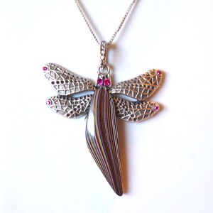 May include: Silver dragonfly pendant necklace with a colorful agate stone body and pink crystal accents.