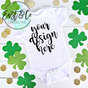 St. Patricks Day White Baby Mockup Infant One Piece Short Sleeve Bodysuit Baby Onesie Flatlay Photo Style Stock Photography Mockup