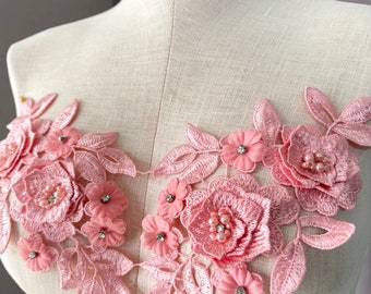 May include: Pink floral lace applique with pearl and rhinestone embellishments. This delicate lace trim is perfect for adding a touch of elegance to any project.