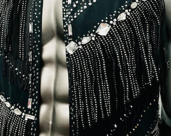 May include: A black sleeveless shirt with a western-style collar and fringe detail. The shirt is covered in rhinestones and sequins.
