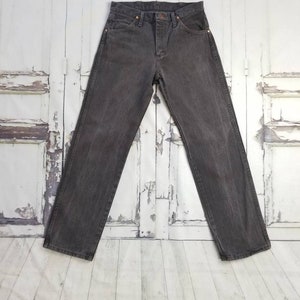 May include: A pair of dark gray denim jeans with a button fly and belt loops.