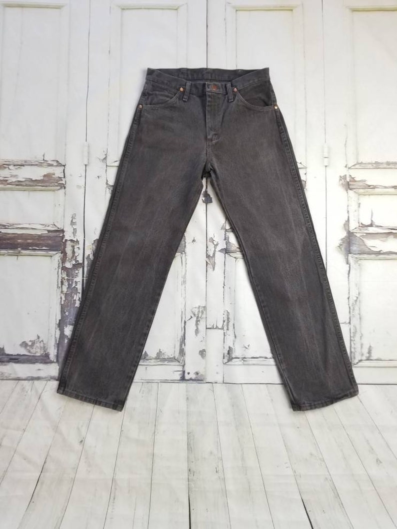 May include: A pair of dark gray denim jeans with a button fly and belt loops.