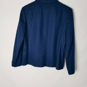 May include: A navy blue blazer with a single button closure and long sleeves.