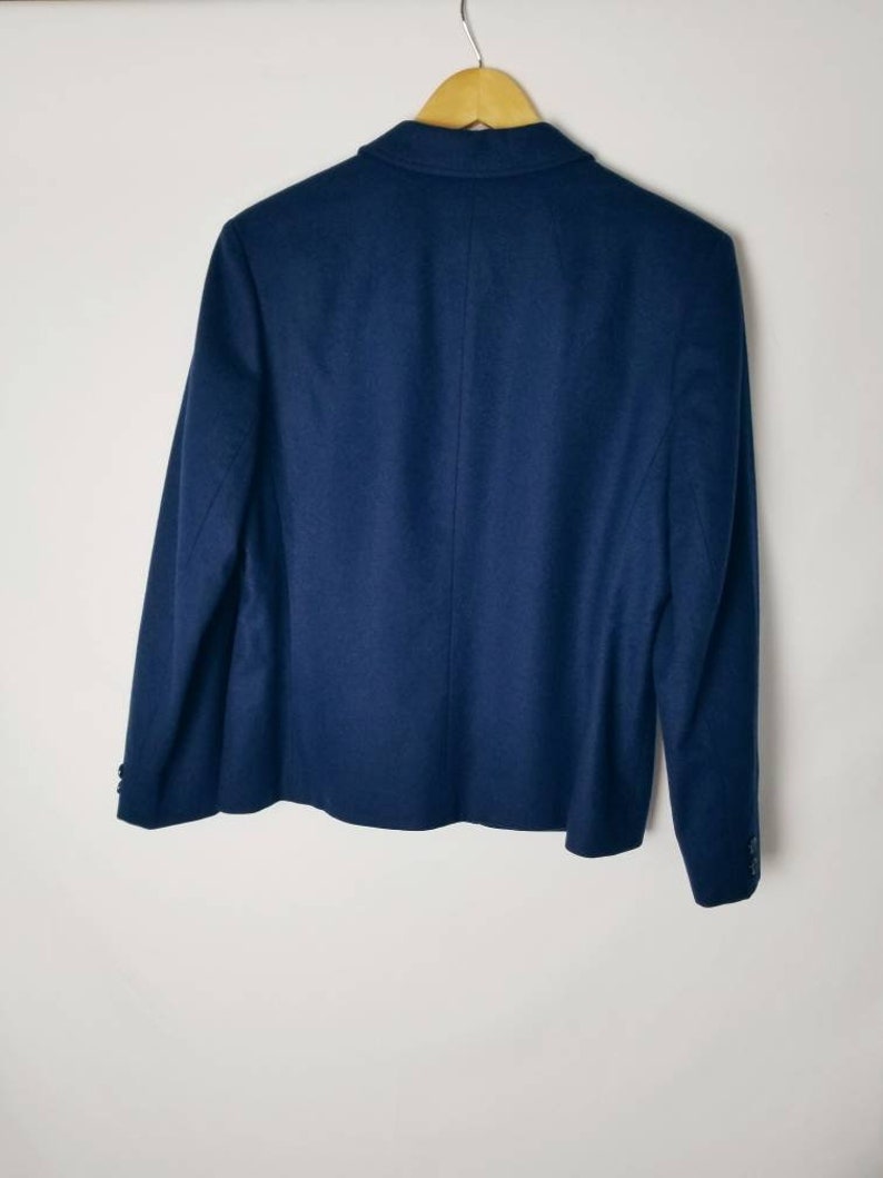 May include: A navy blue blazer with a single button closure and long sleeves.