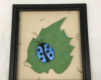 Blue beetle on green leaf