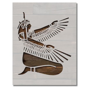 May include: A stencil of an Egyptian goddess with wings outstretched, on a woodgrain background.