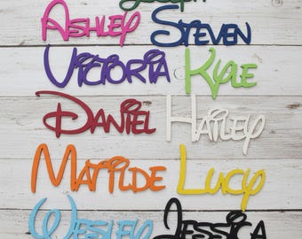 Puede incluir: Una colección de recortes de nombres de madera coloridos en varias fuentes. Los nombres incluyen Joseph, Ashley, Steven, Victoria, Kyle, Daniel, Hailey, Matilde, Lucy, Wesley y Jessica. Los recortes son en tonos de verde, rosa, azul, morado, rojo, naranja, amarillo, negro y blanco.